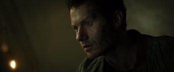 Movie still from “Spectral” (2016), directed by Nic Mathieu – A person looking at the camera; Close Up shot, Low angle