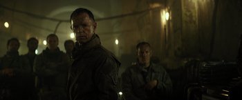 Movie still from “Spectral” (2016), directed by Nic Mathieu – Two men are standing next to each other; Medium shot, Low angle