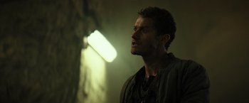 Movie still from “Spectral” (2016), directed by Nic Mathieu – A person in a dark room; Close Up shot, Over the shoulder angle