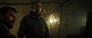 Movie still from “Spectral” (2016), directed by Nic Mathieu – A man in a military uniform standing next to a tree; Close Up shot, Low angle