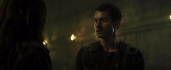 Movie still from “Spectral” (2016), directed by Nic Mathieu – A man standing in a dark room looking to his left; Close Up shot, Over the shoulder angle