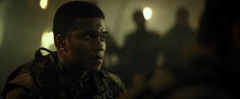 Movie still from “Spectral” (2016), directed by Nic Mathieu – A man in military fatigues looking into the distance; Close Up shot, Over the shoulder angle