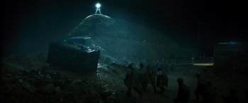 Movie still from “Spectral” (2016), directed by Nic Mathieu – A group of people walking up a hill at night; Extreme Wide shot, Low angle
