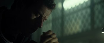 Movie still from “Spectral” (2016), directed by Nic Mathieu – A person with their hands clasped together; Close Up shot, Low angle