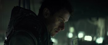 Movie still from “Spectral” (2016), directed by Nic Mathieu – A man's face in the dark; Close Up shot, Low angle