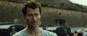 Movie still from “Spectral” (2016), directed by Nic Mathieu – A person wearing a gray t - shirt; Close Up shot, Over the shoulder angle