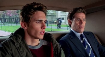 Movie still from “Spider-Man” (2002), directed by Sam Raimi – Two people in a car looking out the back window; Close Up shot, Over the shoulder angle