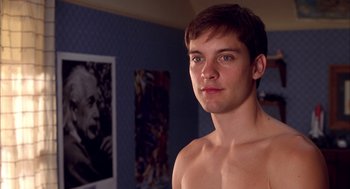 Movie still from “Spider-Man” (2002), directed by Sam Raimi – A young man is standing in front of a portrait; Close Up shot, Over the shoulder angle