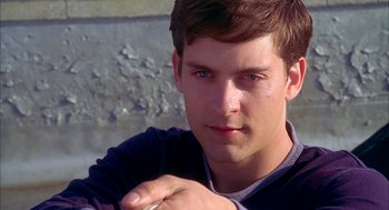 Movie still from “Spider-Man” (2002), directed by Sam Raimi – A young man's face with his hand resting on his chest; Close Up shot, Over the shoulder angle