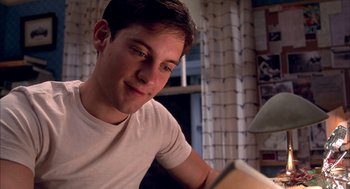 Movie still from “Spider-Man” (2002), directed by Sam Raimi – A man sitting at a table looking at a book; Close Up shot, Over the shoulder angle