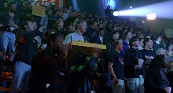 Movie still from “Spider-Man” (2002), directed by Sam Raimi – A group of people in a crowd watching a game; Medium shot, Low angle