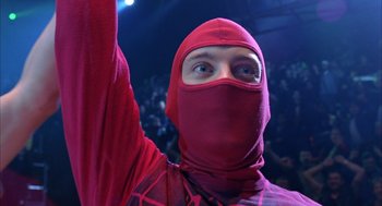 Movie still from “Spider-Man” (2002), directed by Sam Raimi – A man in a red mask is raising his hand; Close Up shot, Overhead angle