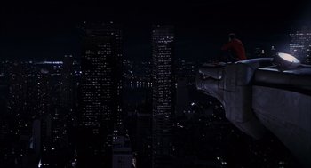 Movie still from “Spider-Man” (2002), directed by Sam Raimi – A man riding a skateboard on top of a building at night; Extreme Wide shot, High angle