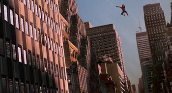 Movie still from “Spider-Man” (2002), directed by Sam Raimi – A man flying through the air in front of tall buildings; Extreme Wide shot, Low angle
