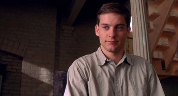 Movie still from “Spider-Man” (2002), directed by Sam Raimi – A young man in a tan shirt is posing for a picture; Close Up shot, Over the shoulder angle