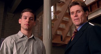 Movie still from “Spider-Man” (2002), directed by Sam Raimi – Two men standing next to each other in front of a building; Close Up shot, Low angle