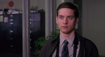 Movie still from “Spider-Man” (2002), directed by Sam Raimi – A man in a suit and tie standing in front of a window; Close Up shot, Over the shoulder angle