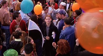 Movie still from “Spider-Man” (2002), directed by Sam Raimi – A group of people standing around each other at an event; Wide shot, High angle