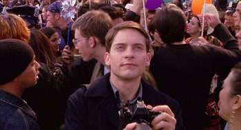 Movie still from “Spider-Man” (2002), directed by Sam Raimi – A man taking a picture of a crowd of people; Close Up shot, Low angle