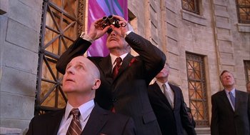 Movie still from “Spider-Man” (2002), directed by Sam Raimi – A group of men in suits and ties looking up at a building; Medium shot, Low angle