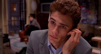 Movie still from “Spider-Man” (2002), directed by Sam Raimi – A man in a suit talking on a cell phone; Close Up shot, High angle