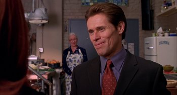 Movie still from “Spider-Man” (2002), directed by Sam Raimi – A man wearing a suit and tie standing next to a woman; Close Up shot, Over the shoulder angle