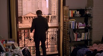 Movie still from “Spider-Man” (2002), directed by Sam Raimi – A man standing on a balcony looking out at a city skyline; Wide shot, High angle