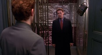 Movie still from “Spider-Man” (2002), directed by Sam Raimi – A man wearing a suit and tie standing next to another man in a suit; Medium shot, Over the shoulder angle