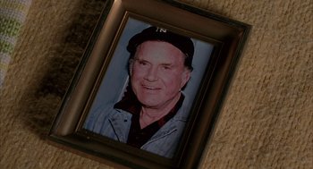 Movie still from “Spider-Man” (2002), directed by Sam Raimi – An old picture of a man in a baseball cap; Extreme Close Up shot, Overhead angle