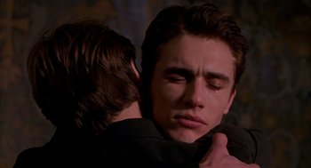 Movie still from “Spider-Man” (2002), directed by Sam Raimi – Two young men embracing each other in a dark room; Close Up shot, Over the shoulder angle