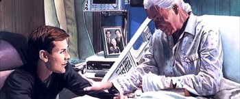 Movie still from “Spider-Man 2” (2004), directed by Sam Raimi – An older woman is using a computer while a younger woman watches; Medium shot, Over the shoulder angle