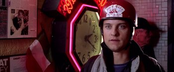 Movie still from “Spider-Man 2” (2004), directed by Sam Raimi – A man wearing a helmet standing in front of a clock; Close Up shot, Over the shoulder angle