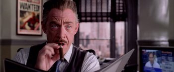 Movie still from “Spider-Man 2” (2004), directed by Sam Raimi – A person holding a cigar; Close Up shot, Over the shoulder angle