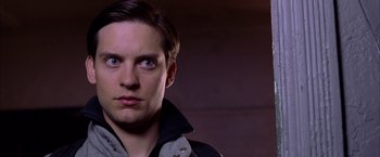 Movie still from “Spider-Man 2” (2004), directed by Sam Raimi – A person wearing a jacket and looking at the camera; Close Up shot, Over the shoulder angle