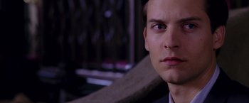 Movie still from “Spider-Man 2” (2004), directed by Sam Raimi – A man's face in a dark room; Close Up shot, Over the shoulder angle