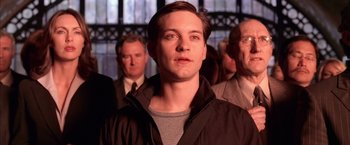 Movie still from “Spider-Man 2” (2004), directed by Sam Raimi – A group of men standing next to each other in a room; Close Up shot, Over the shoulder angle