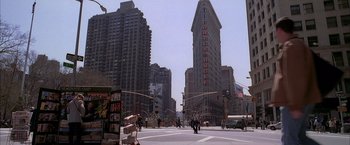 Movie still from “Spider-Man 2” (2004), directed by Sam Raimi – People cross the street in front of the flatiron building in new york city; Extreme Wide shot, Low angle