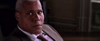 Movie still from “Spider-Man 2” (2004), directed by Sam Raimi – An older man wearing a suit and tie looking at the camera; Close Up shot, High angle