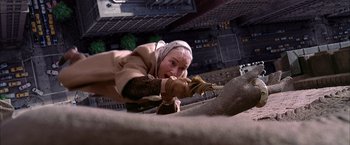 Movie still from “Spider-Man 2” (2004), directed by Sam Raimi – A woman in a tan jacket and a white head scarf is climbing a wall; Close Up shot, Overhead angle
