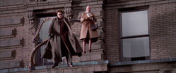 Movie still from “Spider-Man 2” (2004), directed by Sam Raimi – A man and a woman standing on a brick wall; Wide shot, Low angle