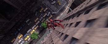 Movie still from “Spider-Man 2” (2004), directed by Sam Raimi – A man in a spider - man costume jumping over a building; Wide shot, Overhead angle