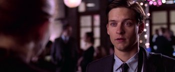 Movie still from “Spider-Man 2” (2004), directed by Sam Raimi – A man in a suit and tie in front of a crowd; Close Up shot, Over the shoulder angle