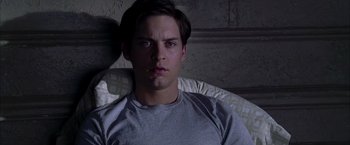 Movie still from “Spider-Man 2” (2004), directed by Sam Raimi – A man sitting in a chair looking at the camera; Close Up shot, High angle