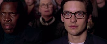 Movie still from “Spider-Man 2” (2004), directed by Sam Raimi – A person wearing glasses; Close Up shot, Over the shoulder angle