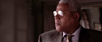 Movie still from “Spider-Man 2” (2004), directed by Sam Raimi – An older man wearing a suit and tie; Close Up shot, Low angle