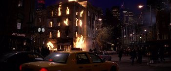 Movie still from “Spider-Man 2” (2004), directed by Sam Raimi – A building on fire in the middle of a city street; Extreme Wide shot, High angle