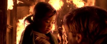 Movie still from “Spider-Man 2” (2004), directed by Sam Raimi – A little girl sitting in front of a fire; Close Up shot, Over the shoulder angle