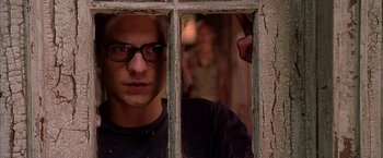 Movie still from “Spider-Man 2” (2004), directed by Sam Raimi – A man with glasses looking through a window; Close Up shot, Over the shoulder angle