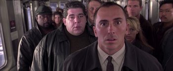 Movie still from “Spider-Man 2” (2004), directed by Sam Raimi – A group of men standing next to each other on a train; Close Up shot, Low angle