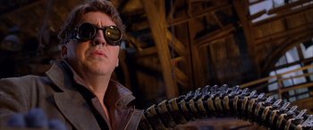 Movie still from “Spider-Man 2” (2004), directed by Sam Raimi – A man wearing sunglasses and holding a gun; Close Up shot, Low angle